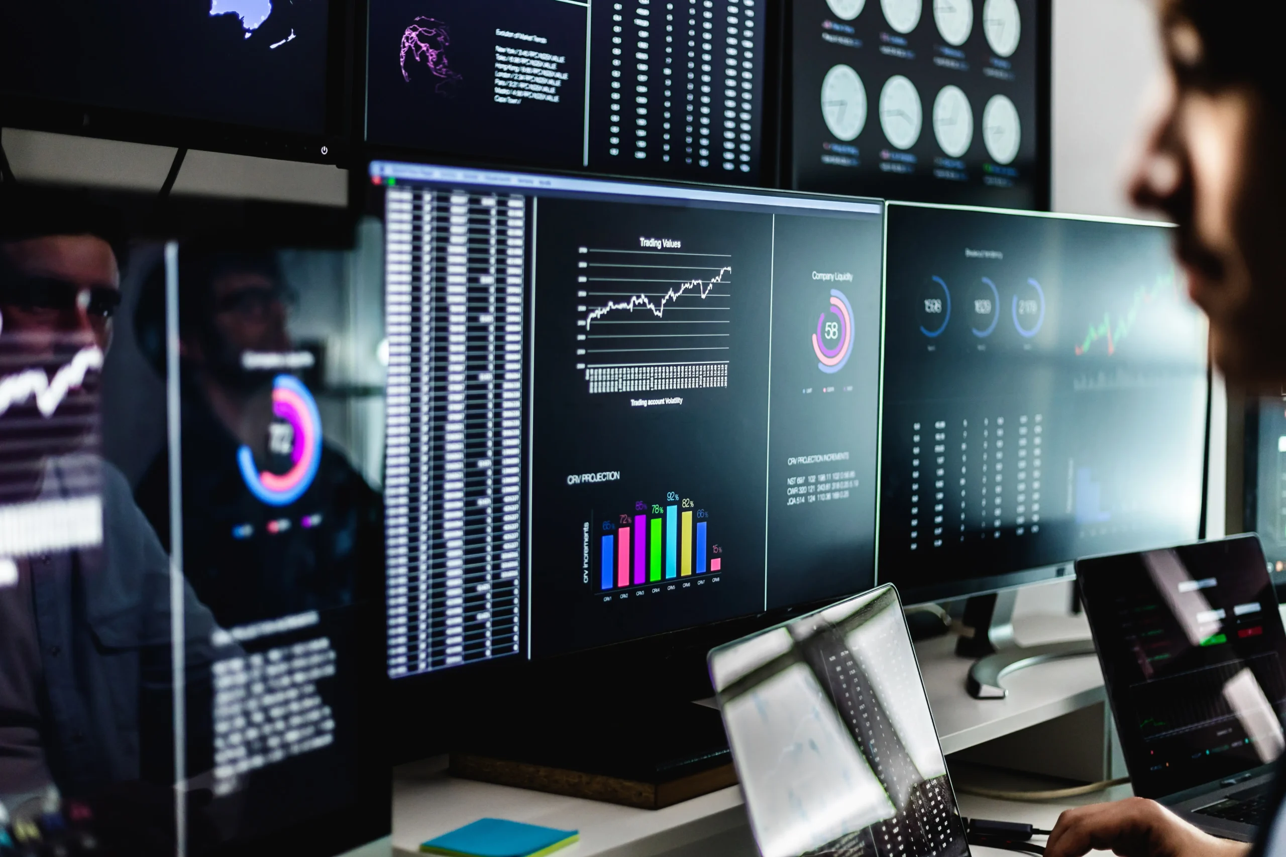 IT speciālists uzrauga sistēmu darbību un datu plūsmas vairākos monitoros – proaktīva IT infrastruktūras uzraudzība un pārvaldība.