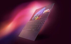 Portatīvais dators peldošā leņķī uz violeti sārta gradienta fona ar Windows 11 sākuma ekrānu